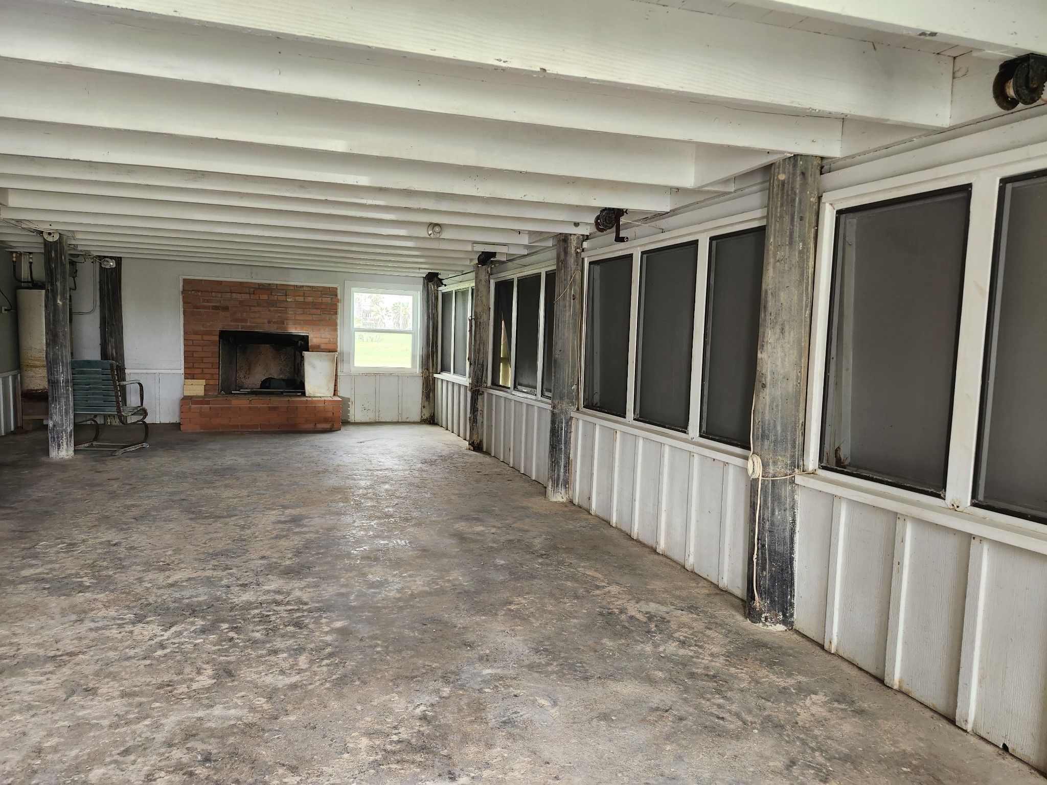 522 Surf Drive Surfside Beach, TX 77541 - Photo 13 of 27 Downstair is open with a 2 changing areas with shower, one has a toilet, and there is a sink out in the large room. The window covers open to let the air in.