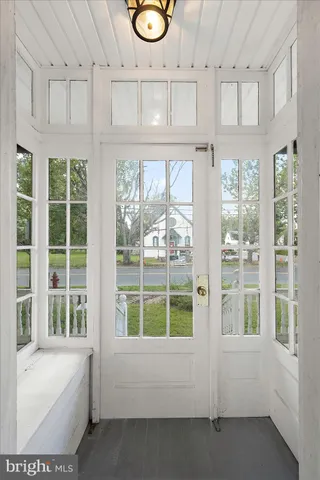 a view of an empty room with wooden floor fireplace and a window