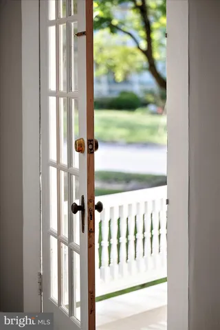 an empty room with wooden floor fireplace and windows