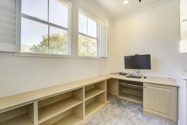 a view of a workspace with furniture and window