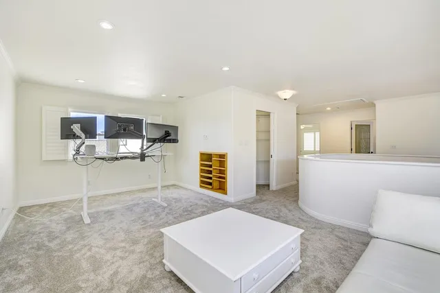 a view of kitchen and empty room with wooden floor
