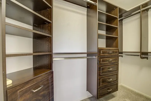 a view of walk in closet with empty racks