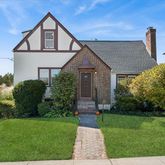 a front view of a house with a yard and outdoor seating