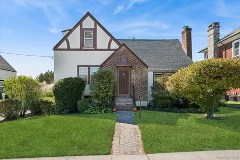 a front view of a house with a yard and outdoor seating