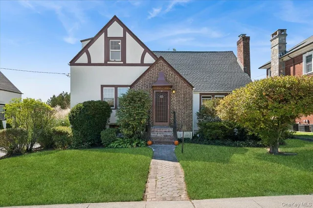 a front view of a house with a yard and outdoor seating