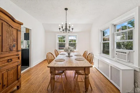 a dining room with furniture a chandelier and wooden floor