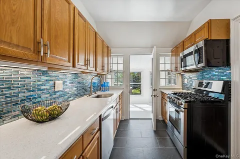 a kitchen with stainless steel appliances granite countertop a stove a sink and a microwave