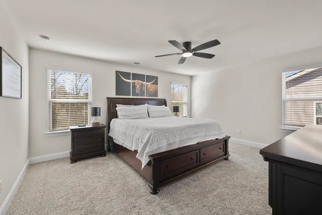 a spacious bedroom with a bed and a flat screen tv