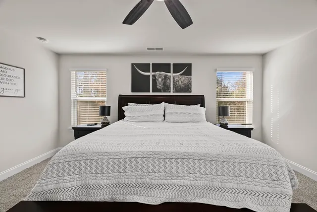 a spacious bedroom with a bed and a flat screen tv