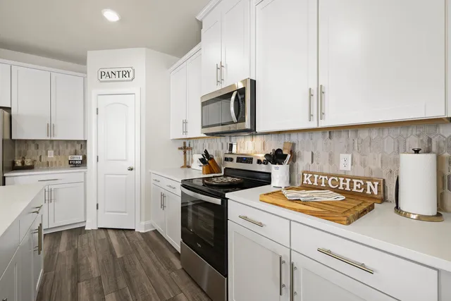 a kitchen with cabinets stainless steel appliances and wooden floor