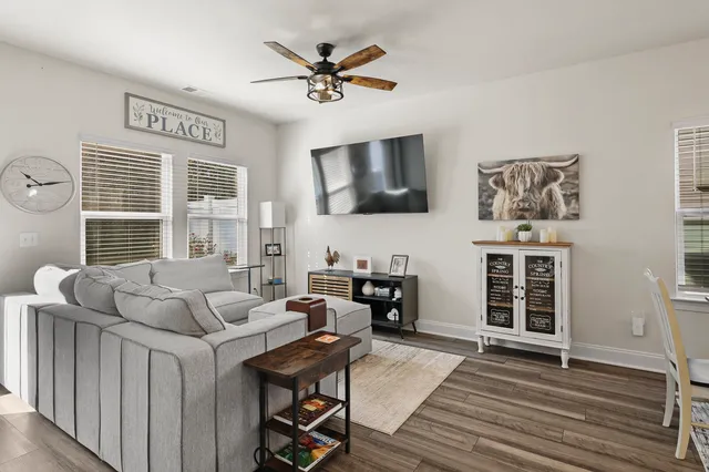 a living room with furniture a flat screen tv and a large window