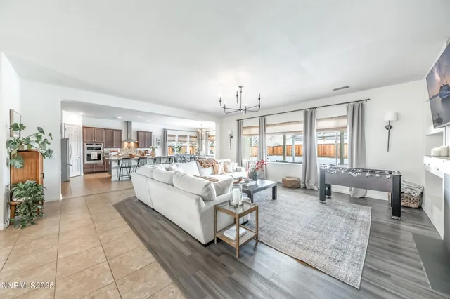 a living room with furniture large window and wooden floor