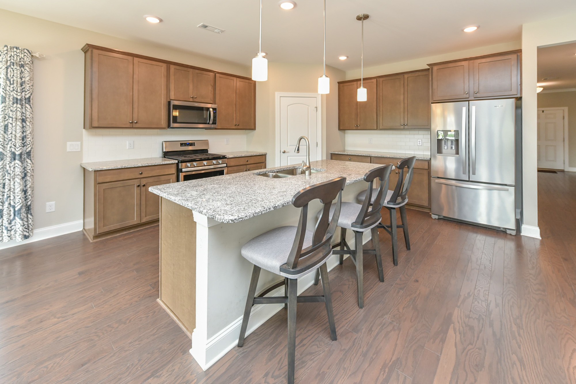 551 Fall Creek Circle Goodlettsville, TN 37072 - Photo 3 of 28 a kitchen with stainless steel appliances granite countertop a refrigerator a stove top oven a sink dishwasher a dining table and chairs with wooden floor