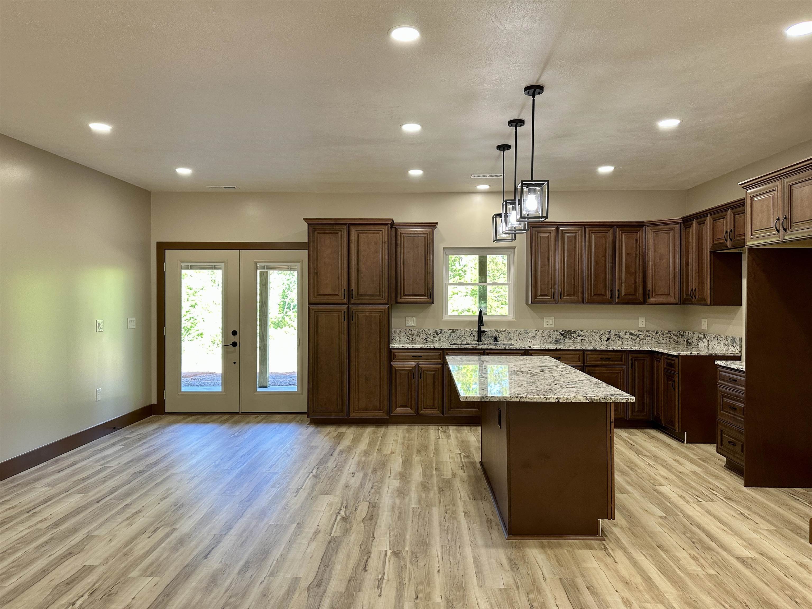1137 Arl Bailey Road Finger, TN 38334 - Photo 5 of 40 a kitchen with granite countertop wooden floors wooden cabinets and stainless steel appliances