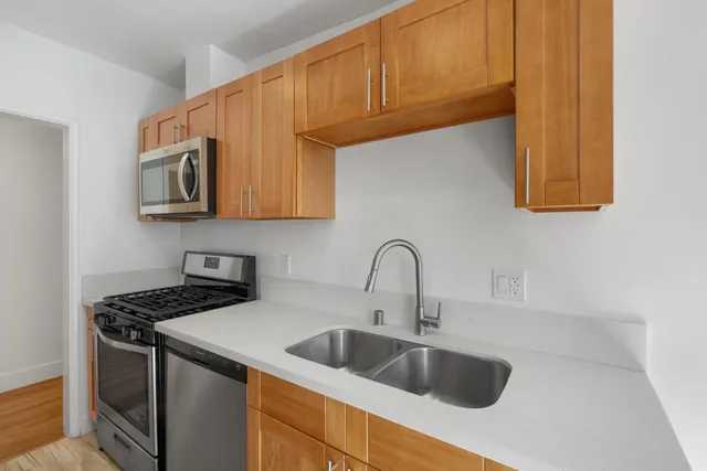 a kitchen with stainless steel appliances a sink a stove and cabinets
