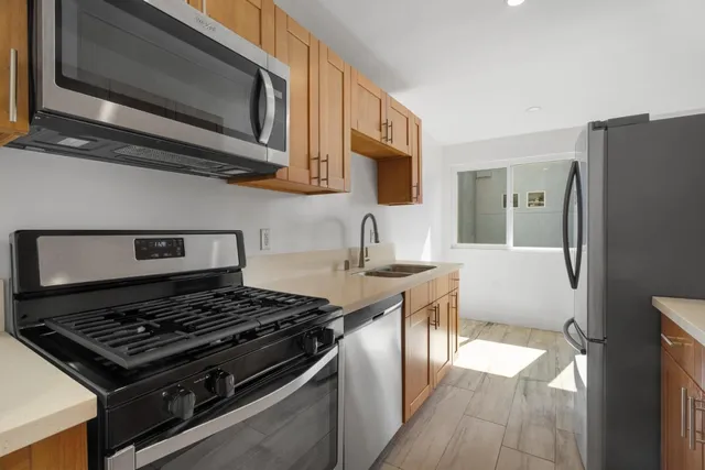 a kitchen with stainless steel appliances granite countertop a stove microwave sink and refrigerator