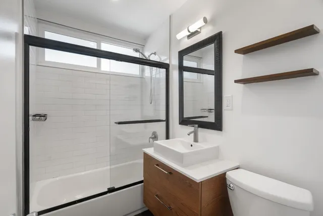 a bathroom with a sink toilet vanity and shower