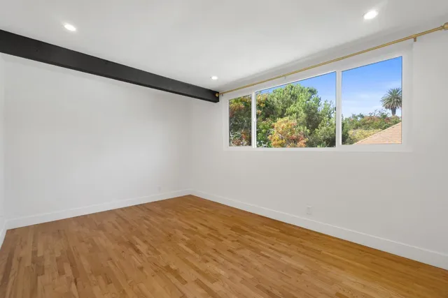 an empty room with wooden floor and a window
