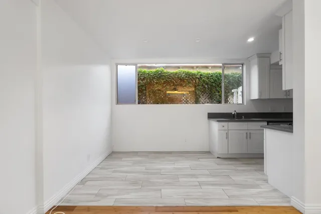 a view of a kitchen with a sink and dishwasher with wooden floor