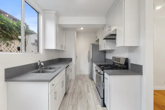 a kitchen with stainless steel appliances granite countertop a sink stove and refrigerator