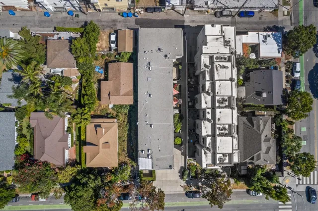 an aerial view of a residential apartment building with yard and parking