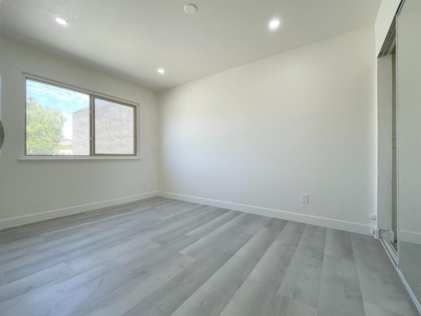 5070 Plaza Corona Santa Clara, CA 95054 - Photo 12 of 18 an empty room with wooden floor and windows
