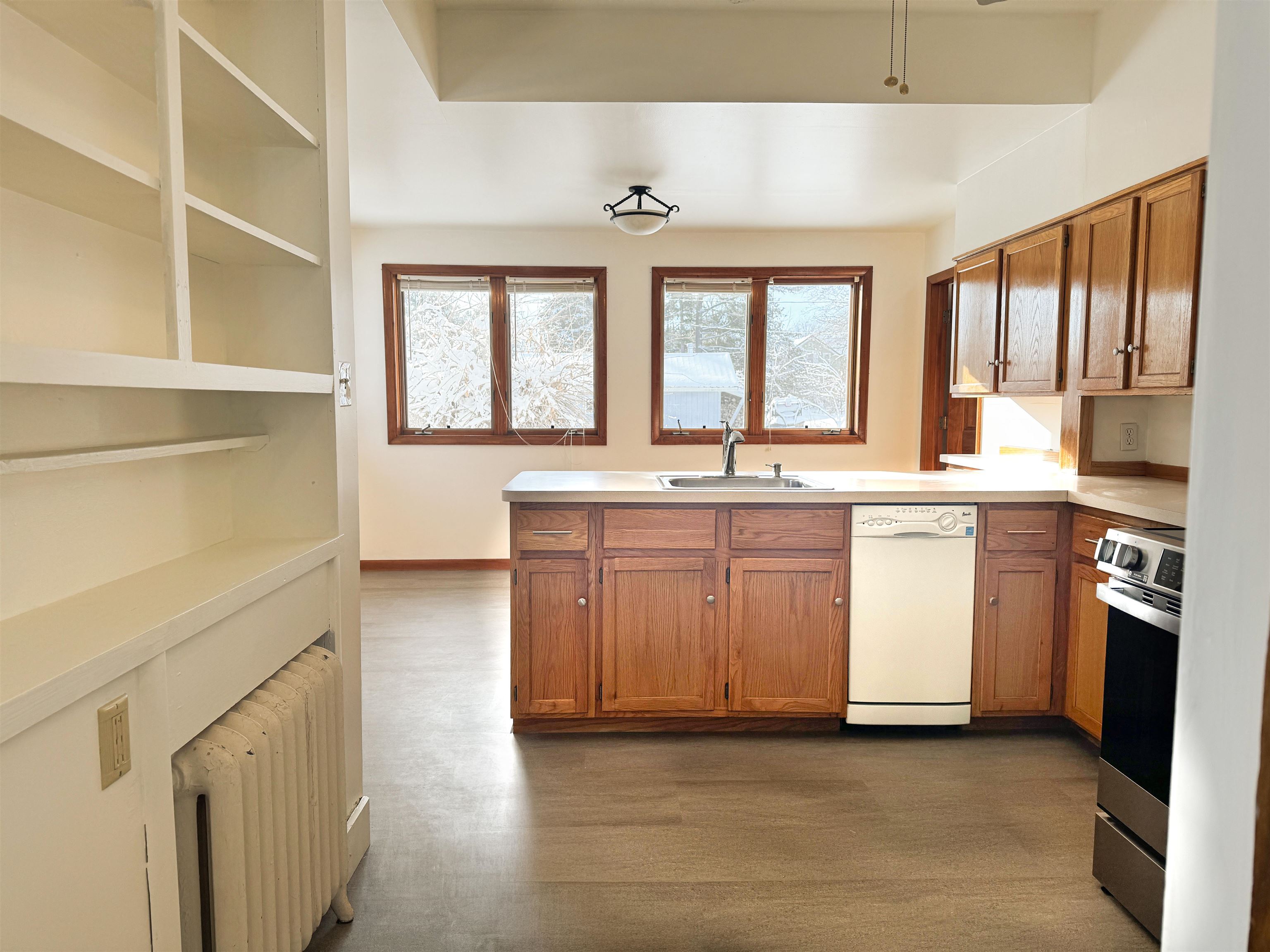315 3rd Avenue East Washburn, WI 54891 - Photo 8 of 14 Kitchen with brown cabinetry, light countertops, radiator, and dishwasher