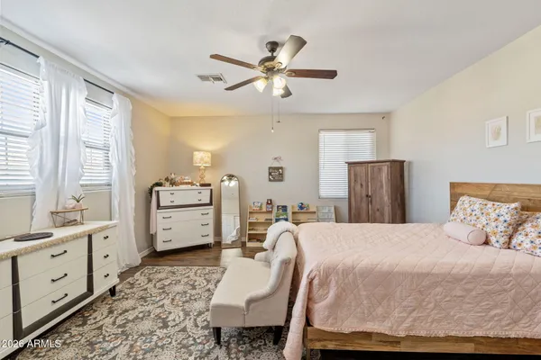 a bedroom with a large bed and wooden floor