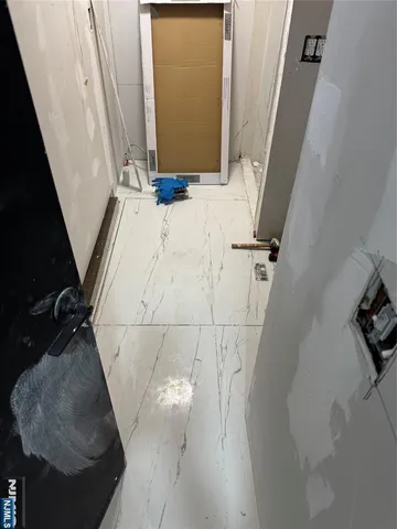a view of a hallway with wooden floor and closet