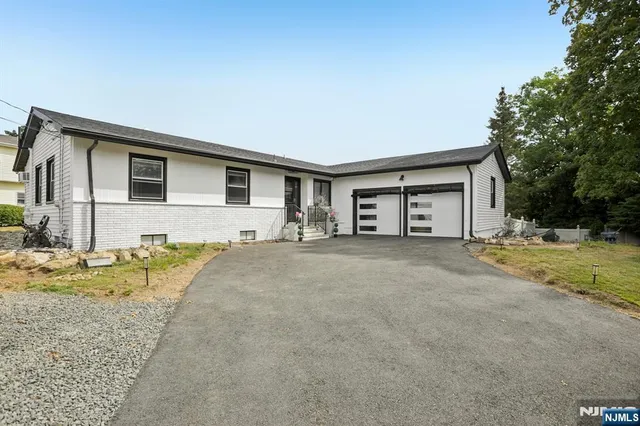 a view of a house with backyard and trees