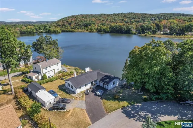 a view of a house with a yard water fountain and large tree