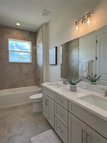 a bathroom with a toilet a sink a tub and mirror