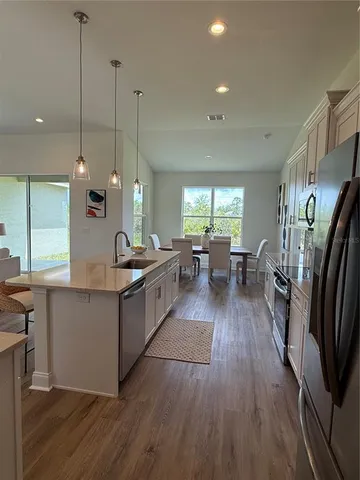 a large kitchen with lots of counter space a sink a window and stainless steel appliances