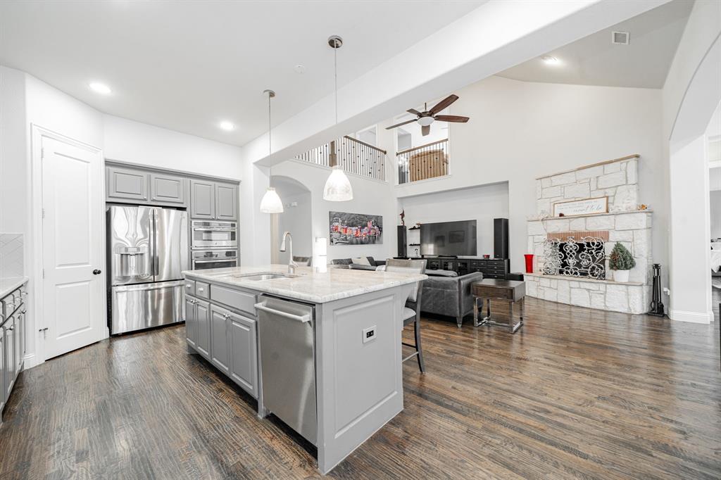 944 Highpoint Way Roanoke, TX 76262 - Photo 11 of 39 a kitchen with stainless steel appliances a stove top oven and cabinets