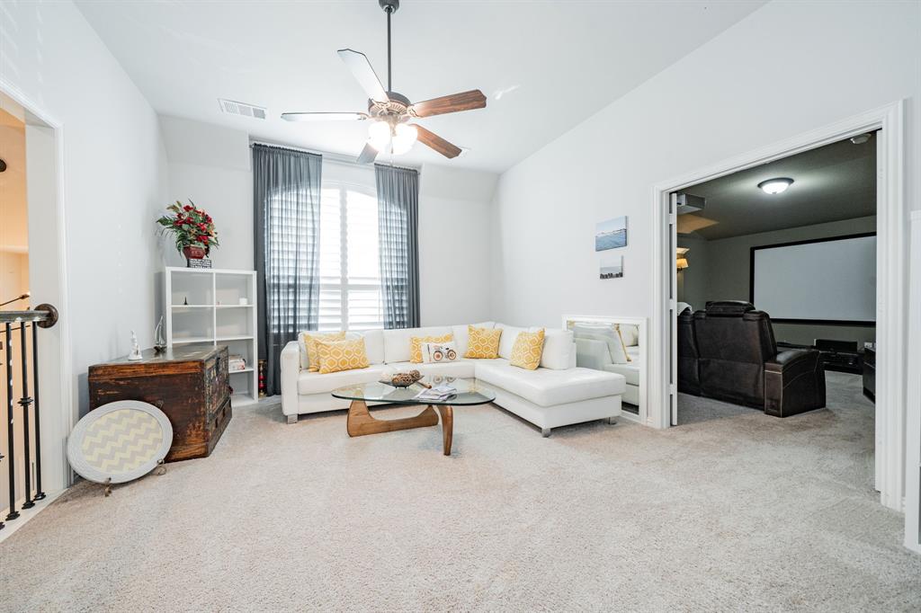 944 Highpoint Way Roanoke, TX 76262 - Photo 27 of 39 a living room with furniture a chandelier and a flat screen tv