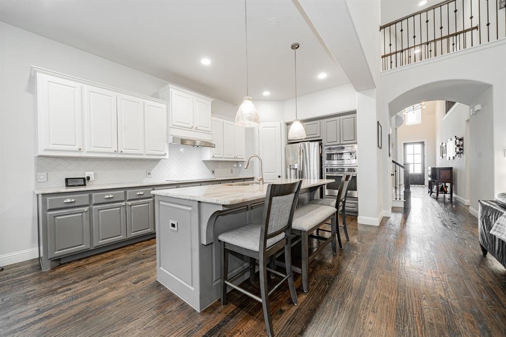 944 Highpoint Way Roanoke, TX 76262 - Photo 10 of 39 a kitchen with stainless steel appliances granite countertop a kitchen island hardwood floor and a sink