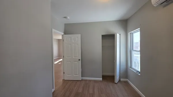 an empty room with wooden floor and a window