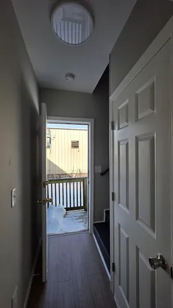 a view of a hallway to a livingroom with furniture