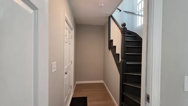 a view of hallway with stairs and a white door