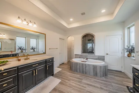 a large spacious bathroom with a double vanity sink a mirror and shower