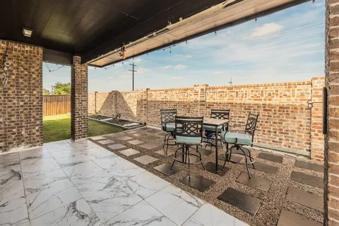 a view of a patio with a dining table and chairs with wooden floor