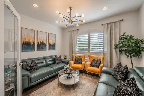 a living room with furniture ceiling fan and a window