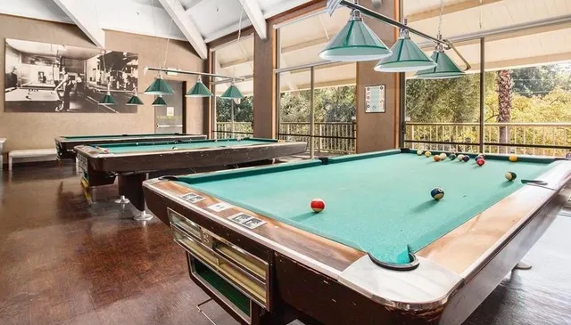 a room with pool table and windows