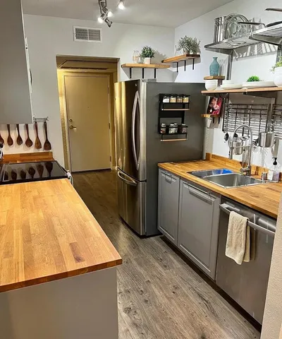 a kitchen with stainless steel appliances granite countertop a refrigerator and a stove