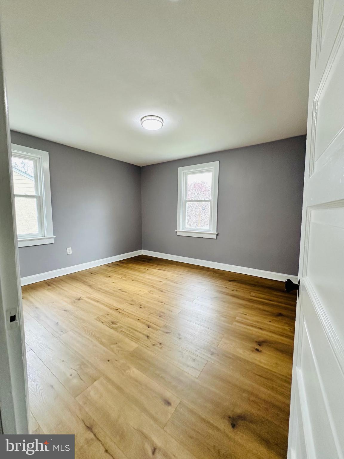 1 Marion Court, Unit 2 Ewing, NJ 08618 - Photo 6 of 9 an empty room with wooden floor and windows
