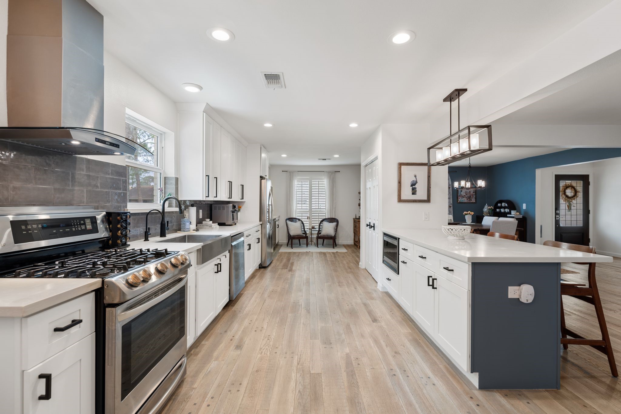10619 Cranbrook Road Houston, TX 77042 - Photo 12 of 32 a large kitchen with stainless steel appliances granite countertop a stove top oven a sink dishwasher and white cabinets with wooden floor