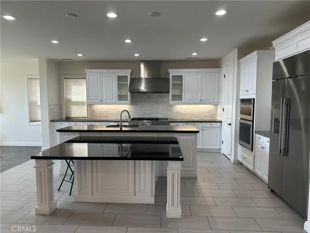 a kitchen with granite countertop a stove and a refrigerator