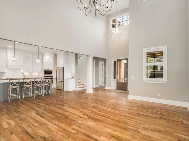a kitchen with stainless steel appliances kitchen island granite countertop a dining table chairs and white cabinets