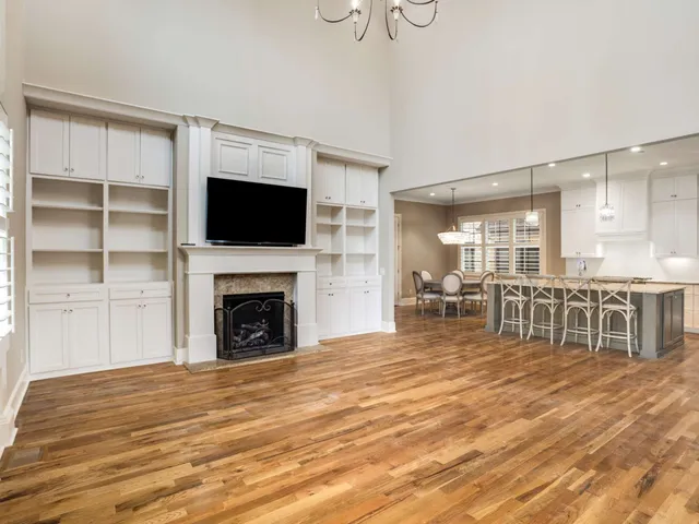 a dining hall with stainless steel appliances a dining table chairs and view living room