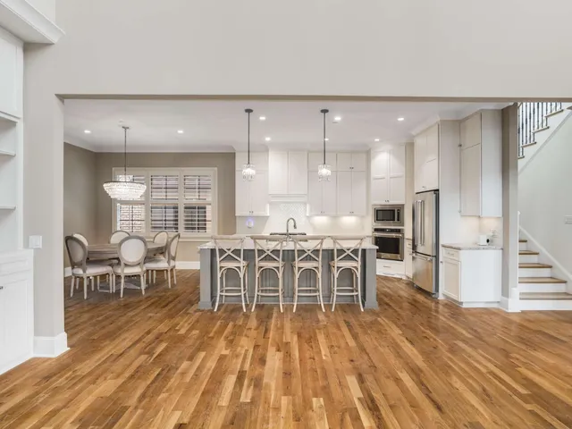 a kitchen with stainless steel appliances granite countertop a stove a sink dishwasher and a refrigerator with wooden floor